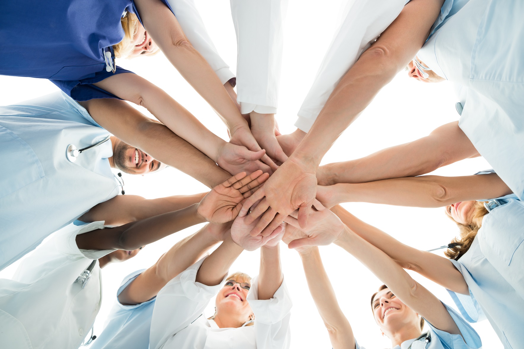 Directly,Below,Shot,Of,Multiethnic,Medical,Team,Stacking,Hands,Over
